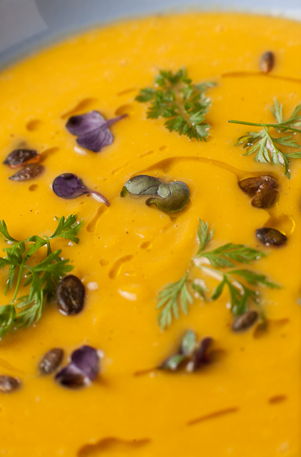 Pumpkin soup with micro herbs, candied pumpkin seeds and a drizzle of oil