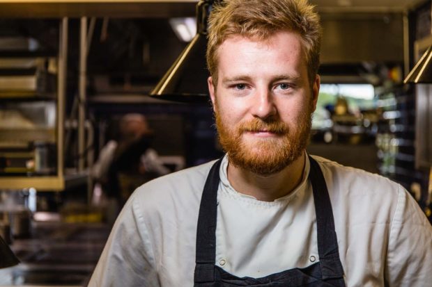 Portrait of male bearded chef with red hair in a commercial kitchen
