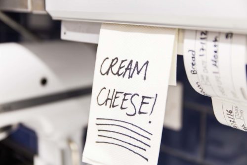 Closeup of a reminder note in a pastry kitchen with cream cheese written on it