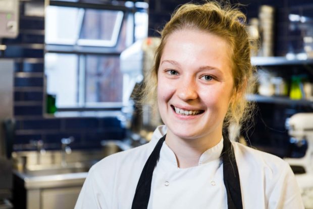 Portrait of female chef in a commercial kitchen, smiling
