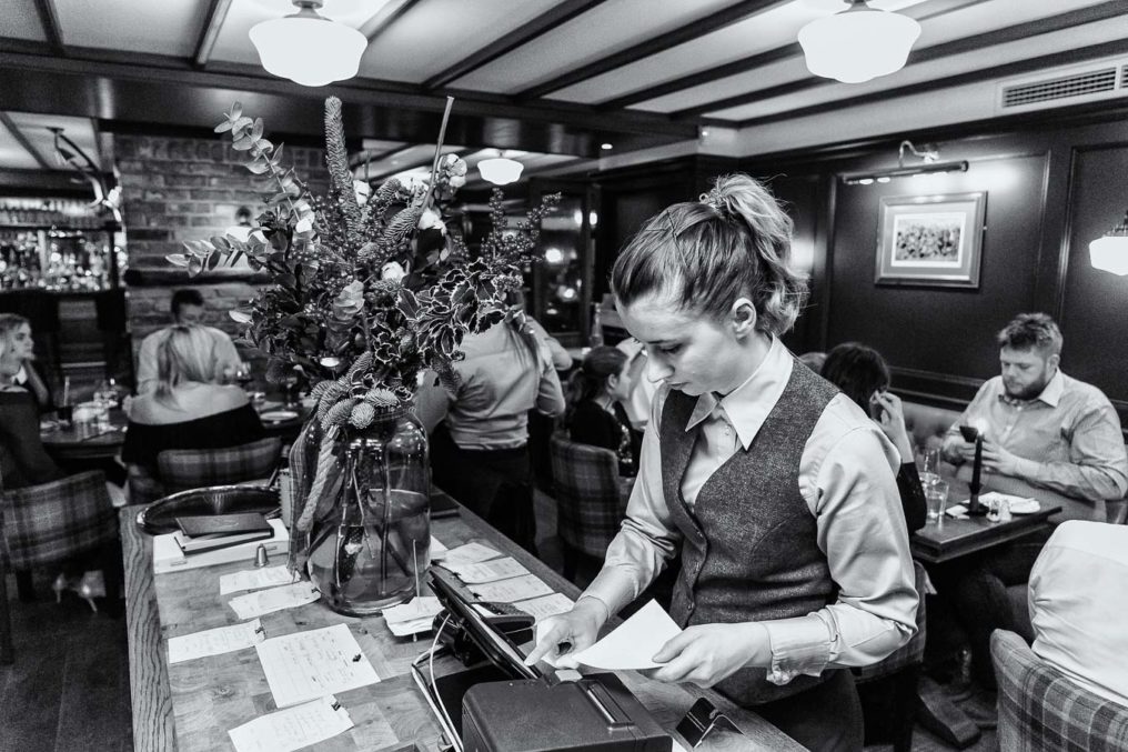 Female front of house staff using the ordering system in the dining room of The Oxford Blue Pub, Windsor by Chef Steven Ellis